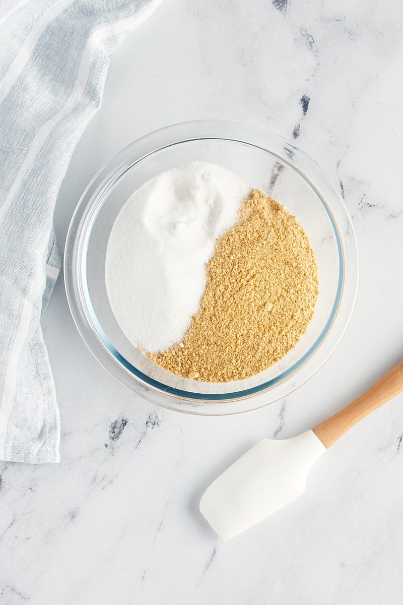 Graham cracker crumbs and sugar in a glass bowl.