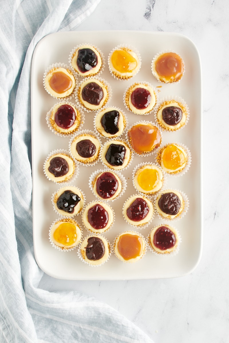 Overhead view of assorted mini cheesecakes on tray