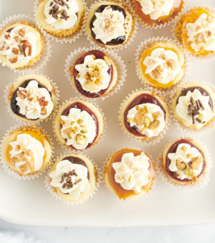 Overhead view of assorted mini cheesecakes on tray