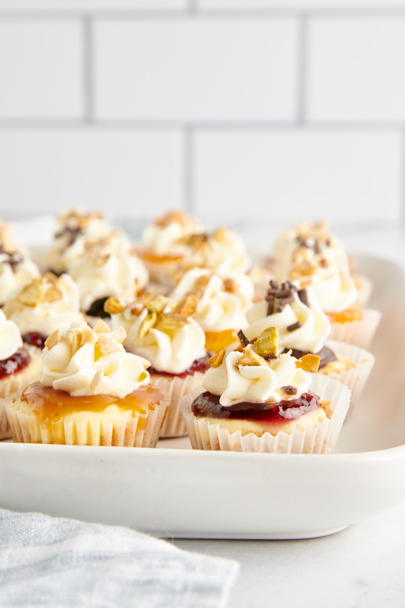 Mini cheesecakes with assorted toppings on tray