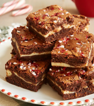 Peppermint Cheesecake Brownies stacked on a red-rimmed white plate