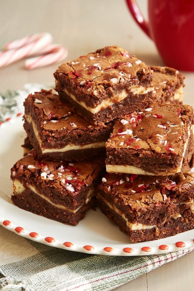 Peppermint Cheesecake Brownies stacked on a red-rimmed white plate