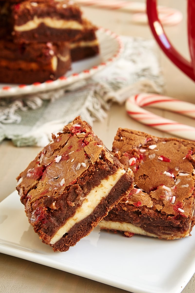 two Peppermint Cheesecake Brownies on a square white plate