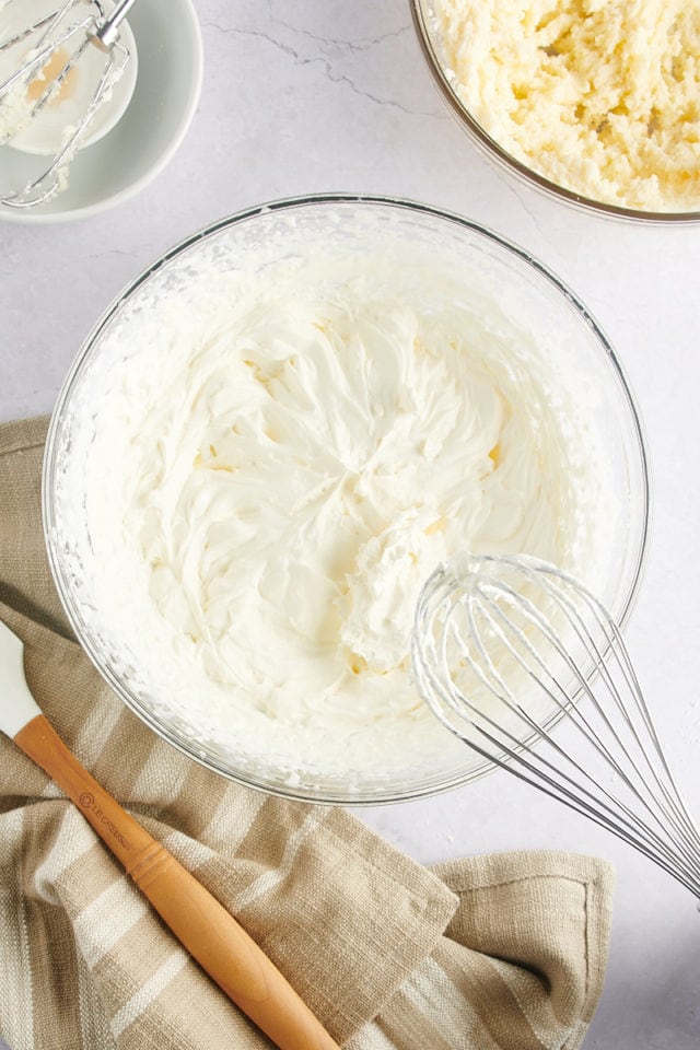 Whipped cream in a mixing bowl with a whisk.