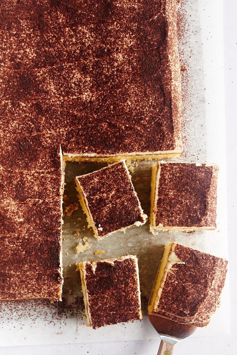 Overhead view of tiramisu cake with 4 pieces cut
