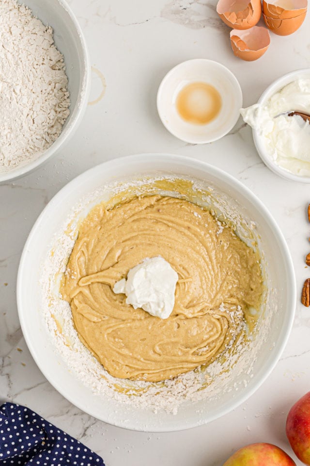 Overhead view of sour cream added to coffee cake batter