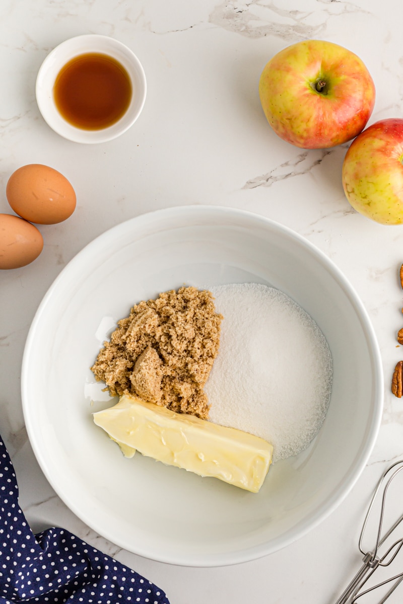 Overhead view of butter and sugars in mixing bowl