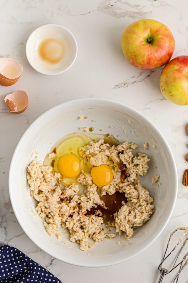 Overhead view of eggs and cinnamon added to mixing bowl