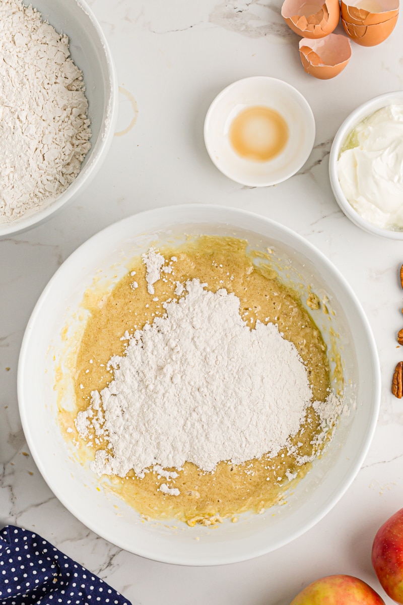 Overhead view of dry ingredients added to batter in mixing bowl