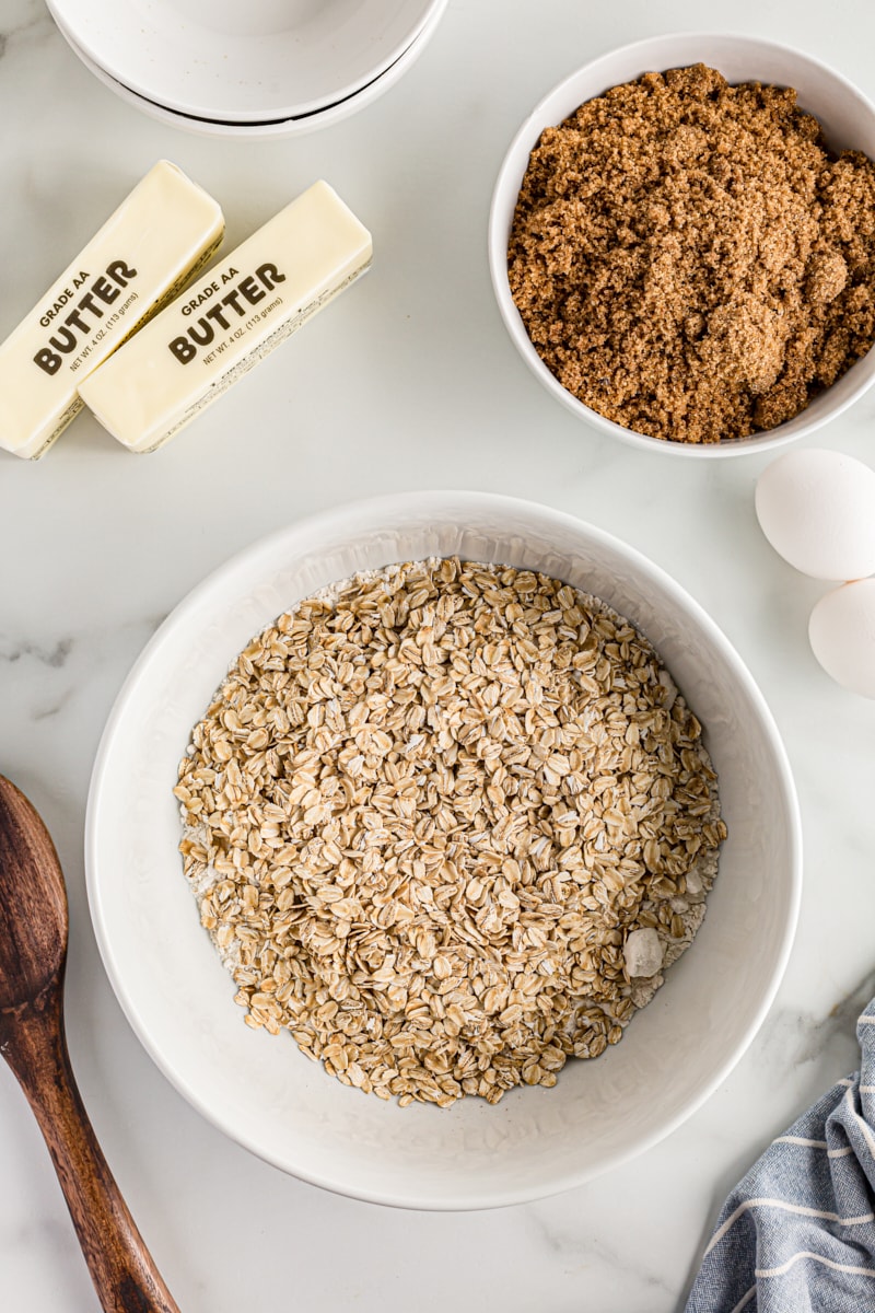 Overhead view of oats, brown sugar, butter, and eggs on countertop