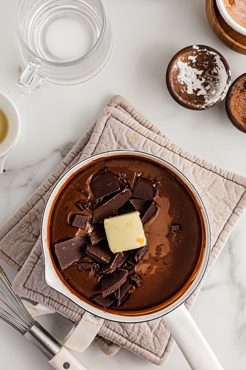 Overhead view of butter and bittersweet chocolate added to pan of pudding