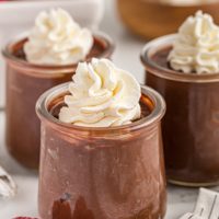3 jars of double chocolate pudding with whipped cream on top