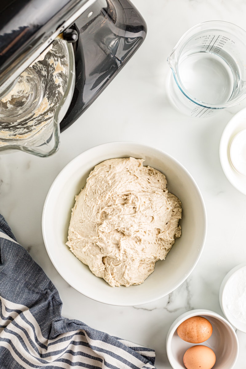 overhead view of pretzel dough in a white mixing bowl