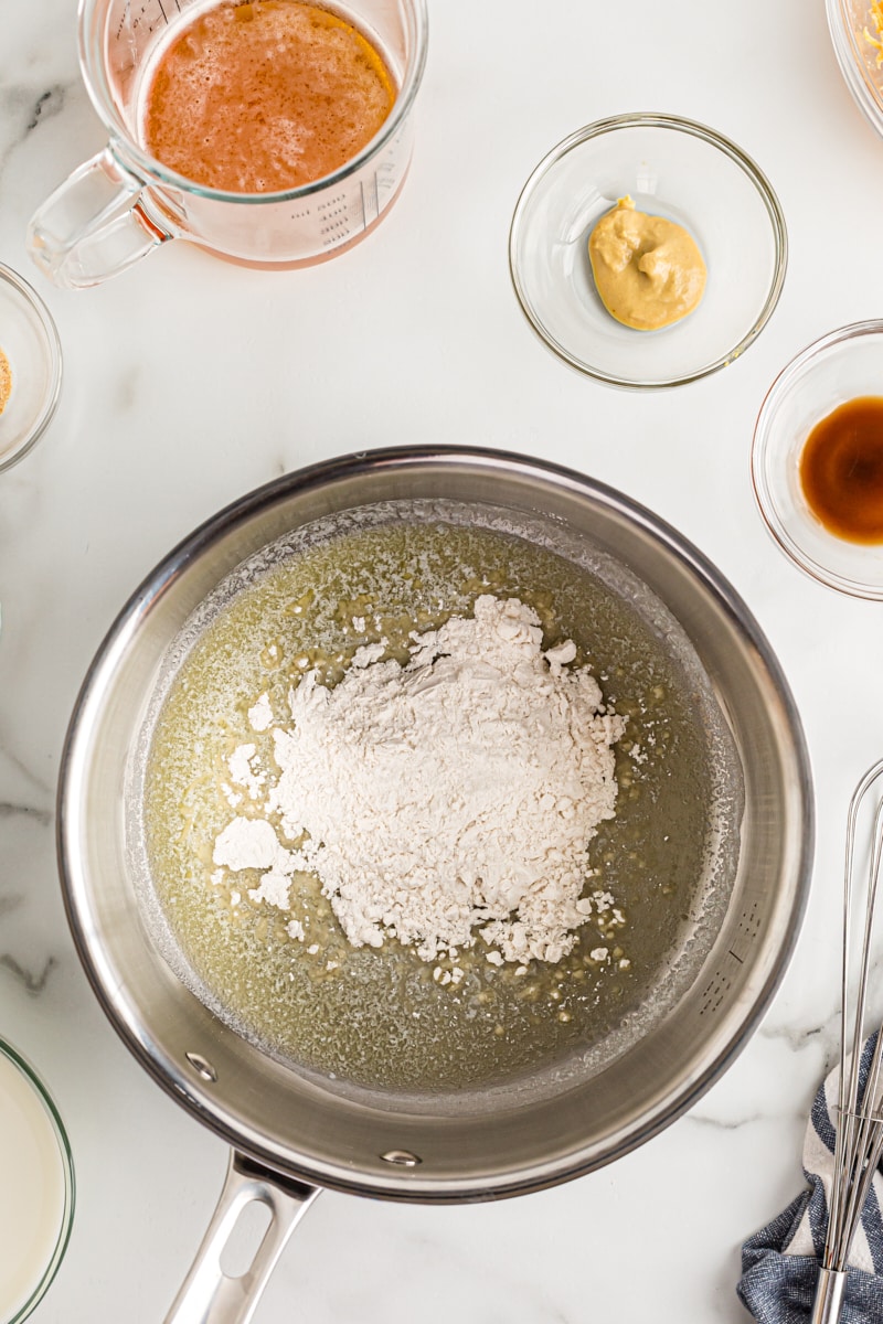 overhead view of flour added to melted butter in a saucepan