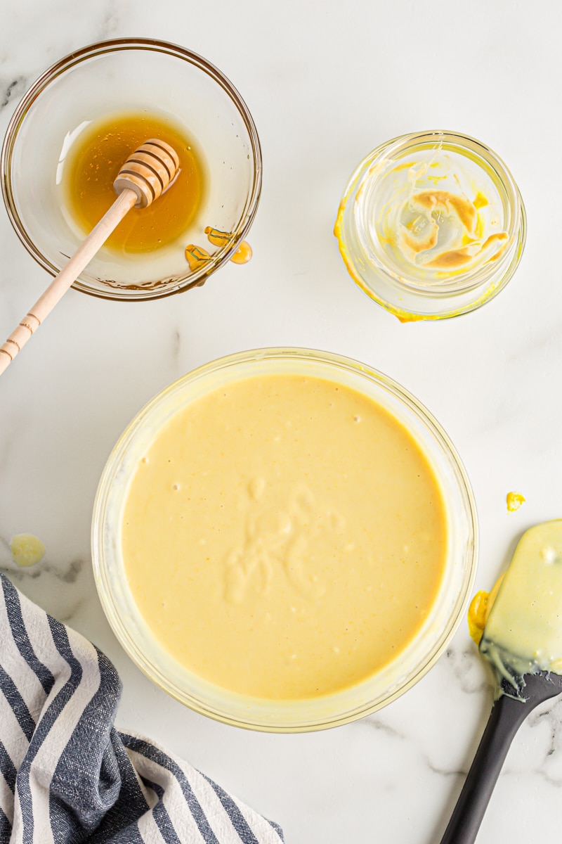 overhead view of mixed honey mustard dipping sauce in a glass mixing bowl