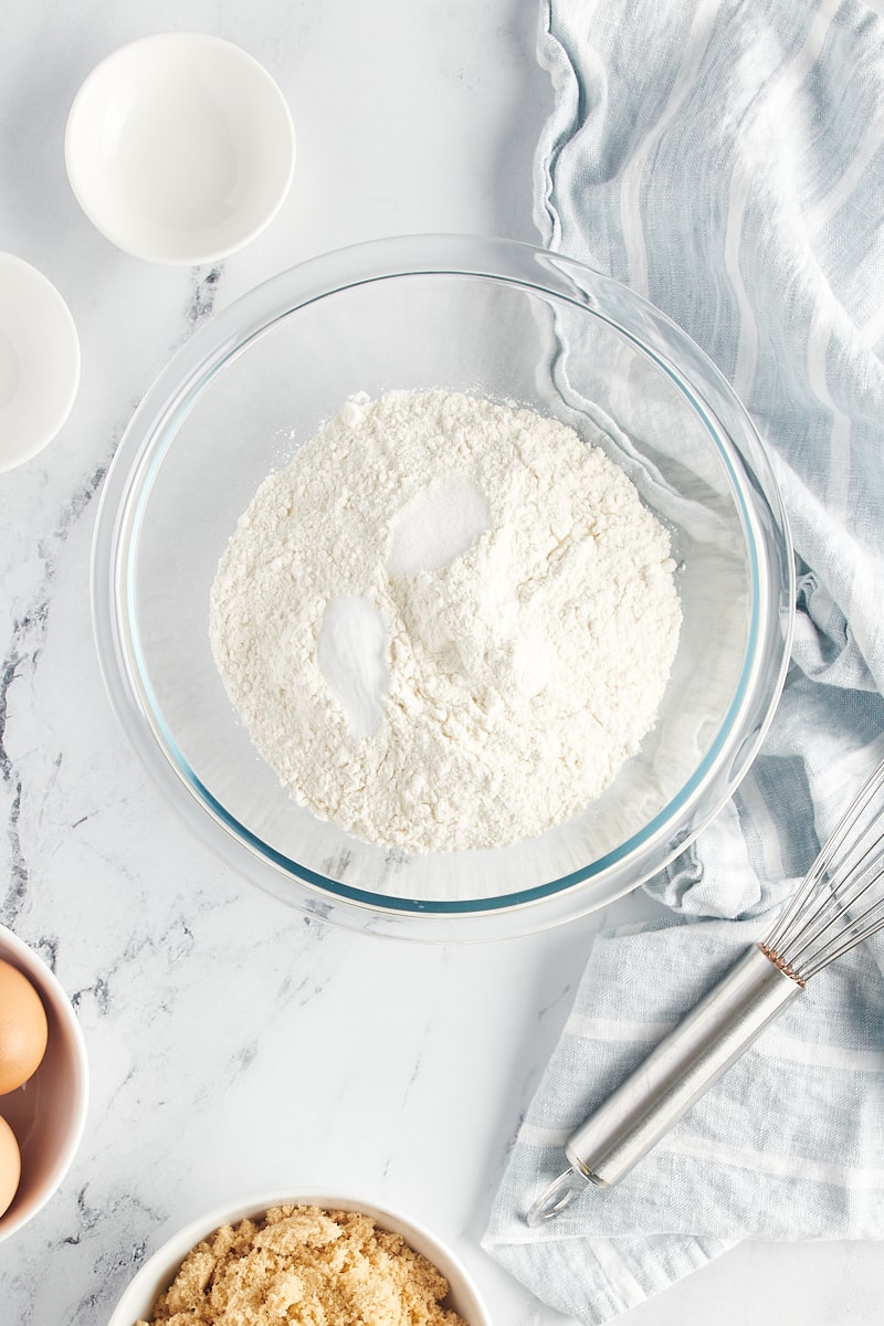 overhead view of flour, baking soda, and salt in a glass mixing bowl