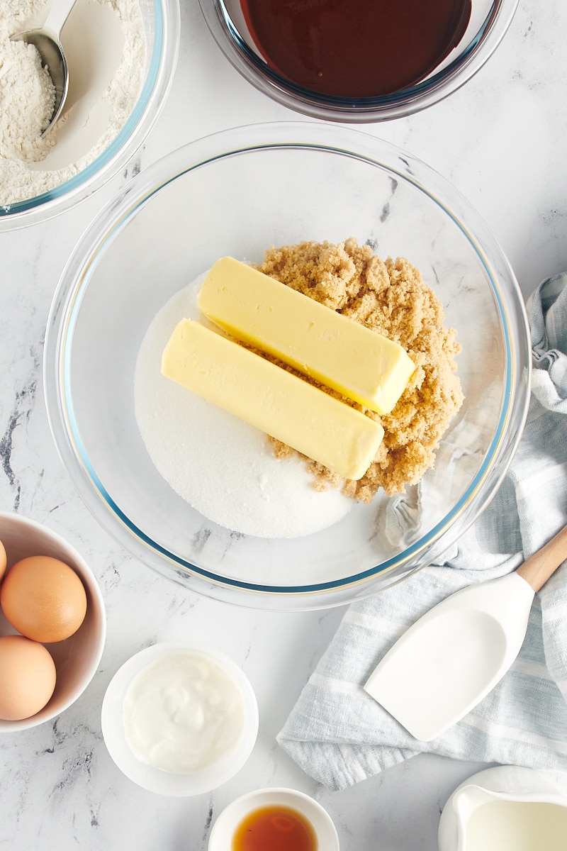 overhead view of butter, sugar, and brown sugar in a glass mixing bowl