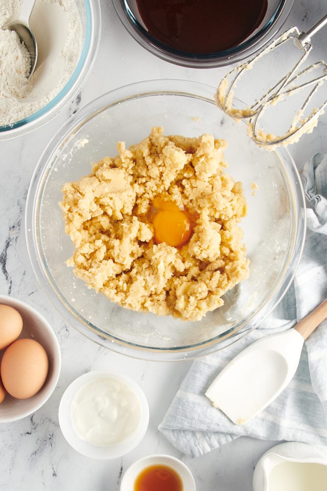 overhead view of egg added to creamed butter and sugar