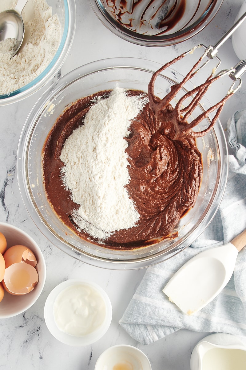 overhead view of a portion of dry ingredients added to chocolate cake batter