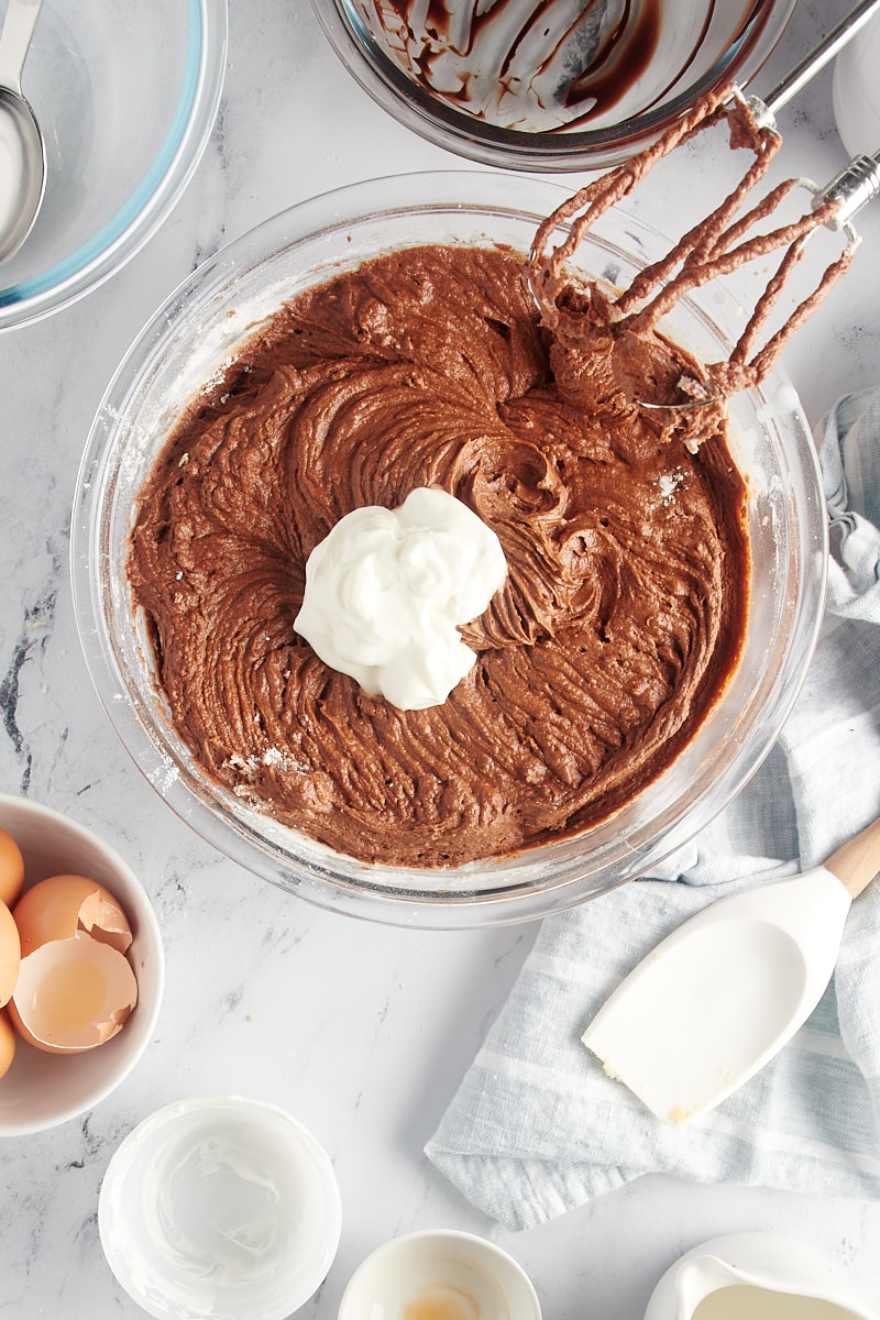 overhead view of sour cream added to chocolate cake batter