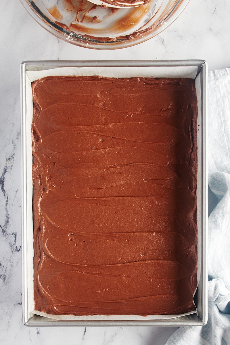 overhead view of chocolate cake batter spread in a 9x13 baking pan