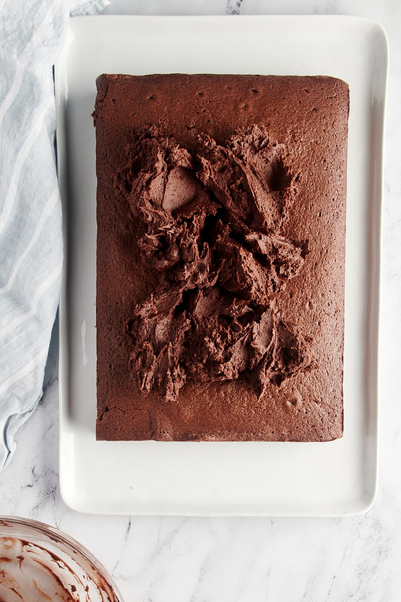 overhead view of chocolate buttercream frosting on top of a chocolate sheet cake