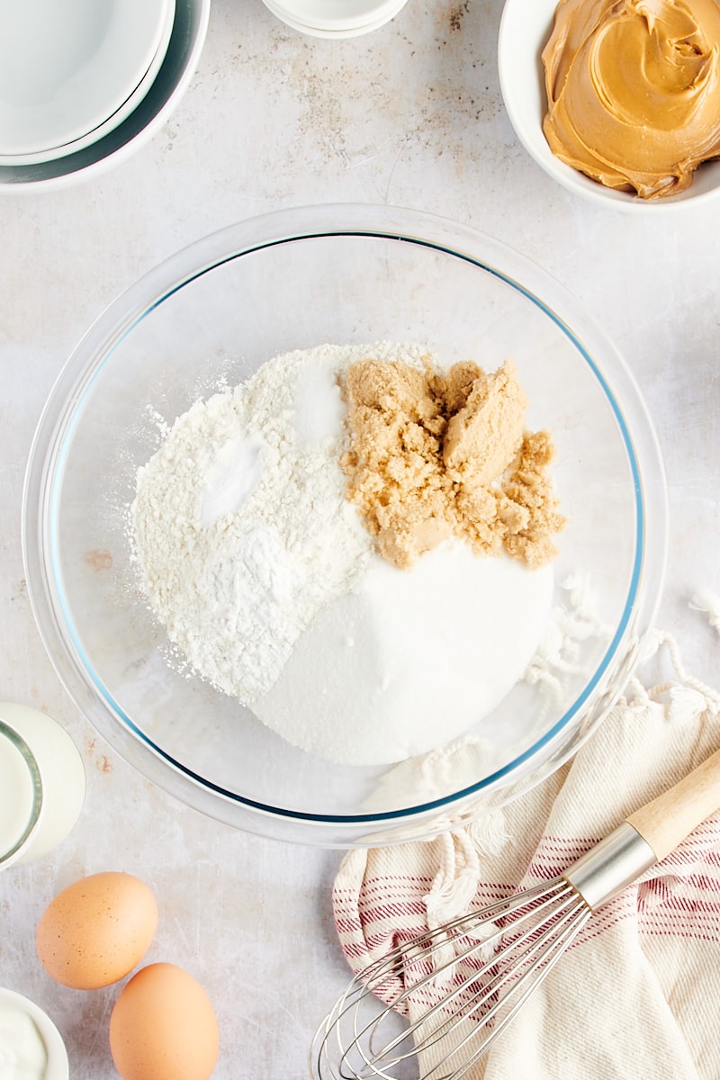 overhead view of dry ingredients and sugars in a glass mixing bowl