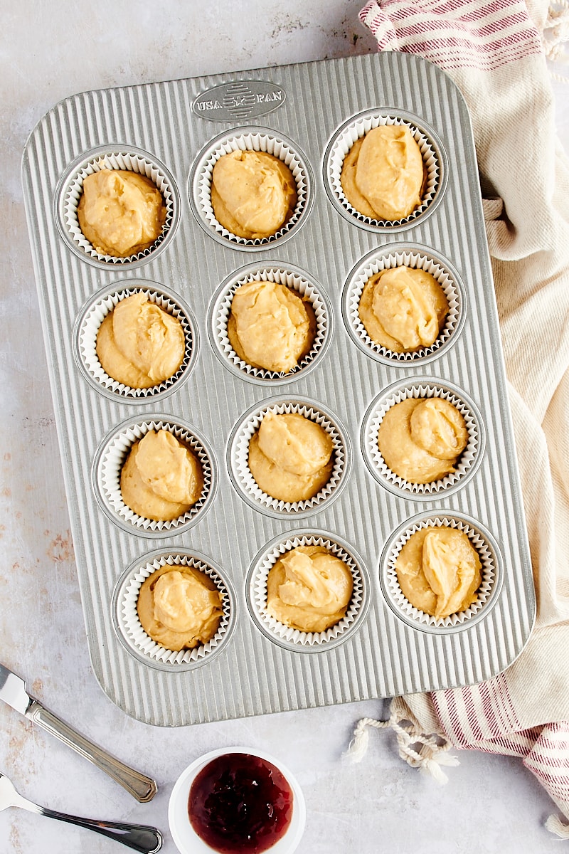 overhead view of portioned Peanut Butter and Jelly Muffin batter in a muffin pan