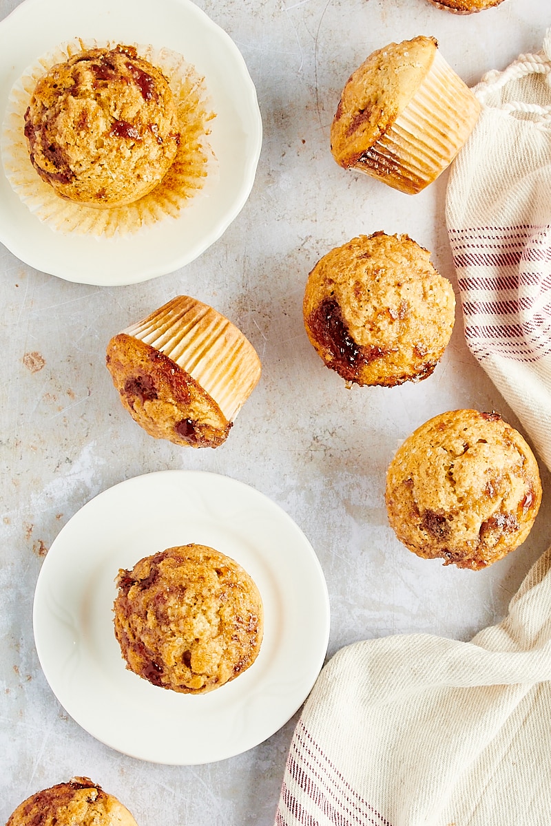 overhead view of Peanut Butter and Jelly Muffins on white plates and a kitchen countertop