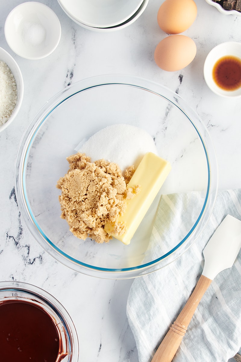 Overhead view of butter and sugars in glass bowl