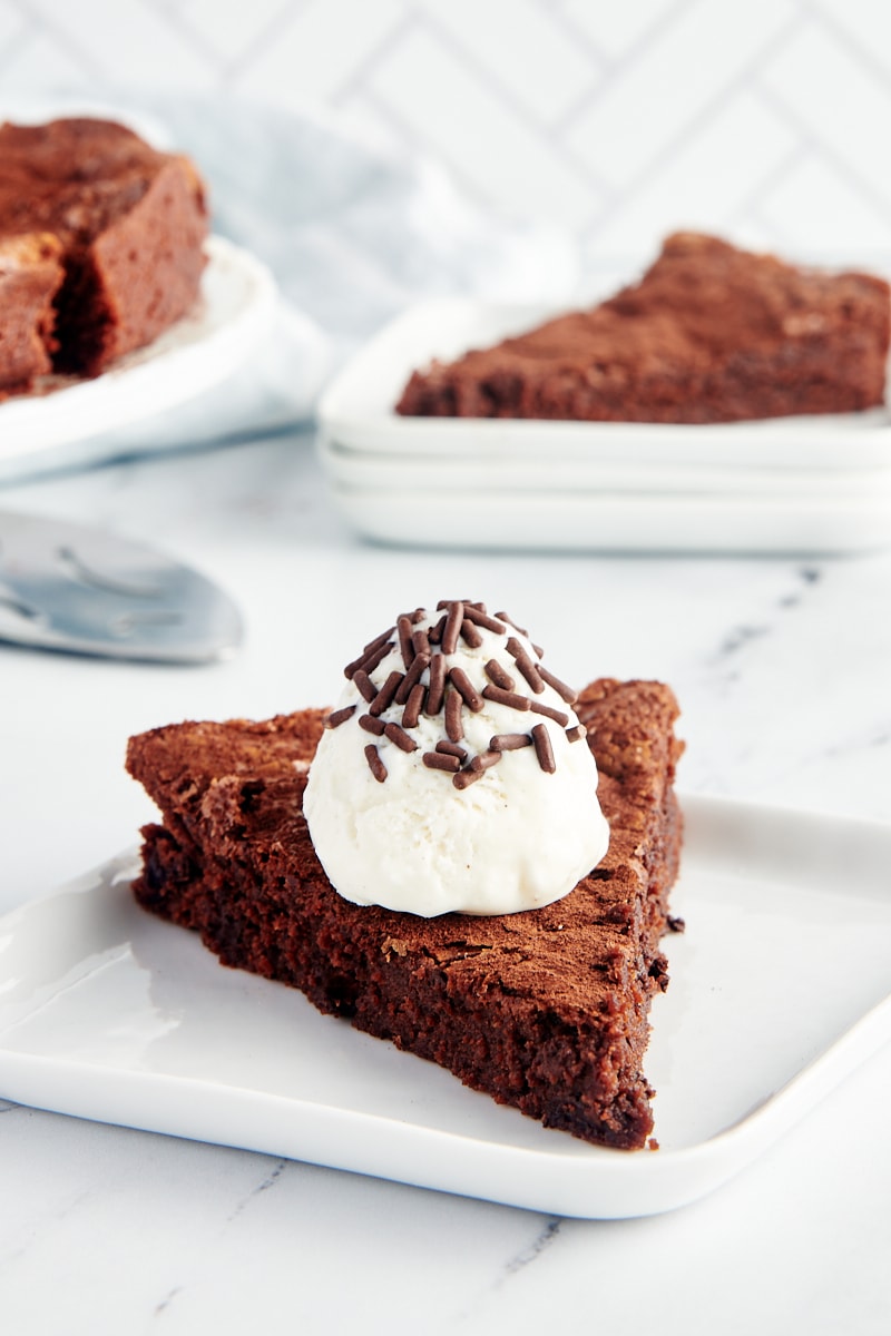 Slice of brownie cake on plate with whipped cream and sprinkles