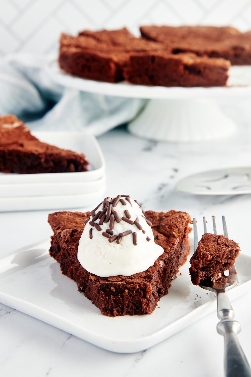 Slice of brownie cake topped with whipped cream