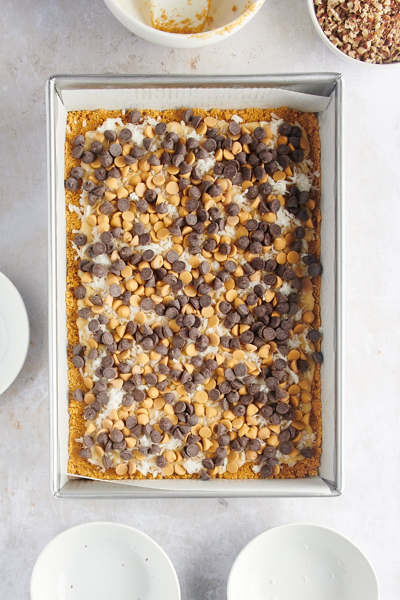 Overhead view of seven layer bars after adding chocolate and butterscotch chips
