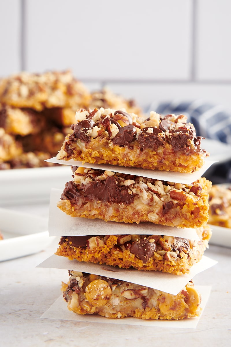 Stack of 4 seven layer bars with parchment paper between each