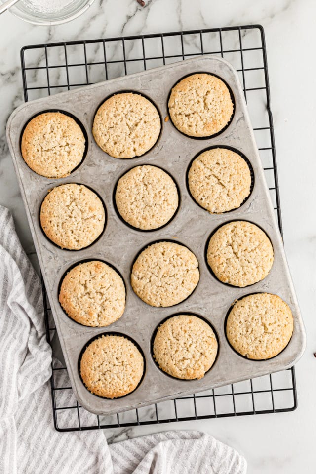 Overhead view of chocolate-filled cupcakes in pan on cooling rack