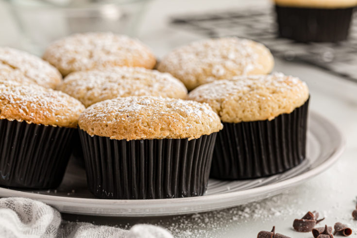 Plate of chocolate-filled cupcakes topped with powdered sugar