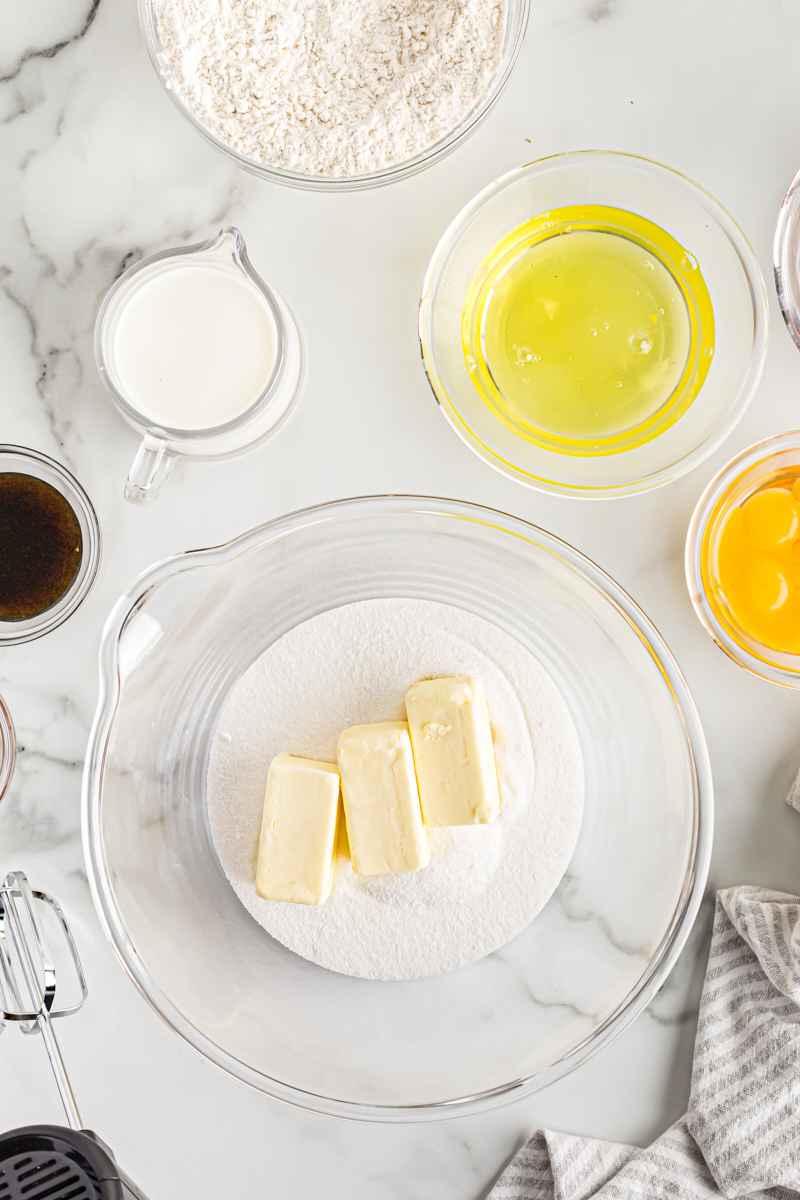 Overhead view of butter and sugar in glass mixing bowl