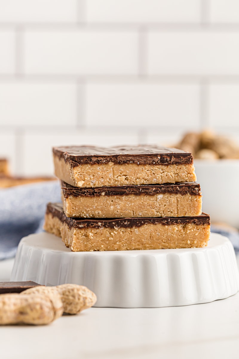 3 no-bake peanut butter chocolate bars stacked on inverted tart pan