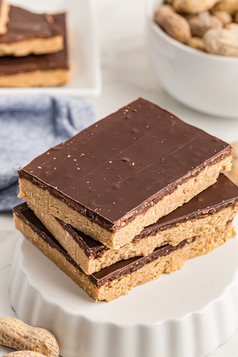 Overhead view of three no-bake peanut butter bars stacked on an inverted tart pan.