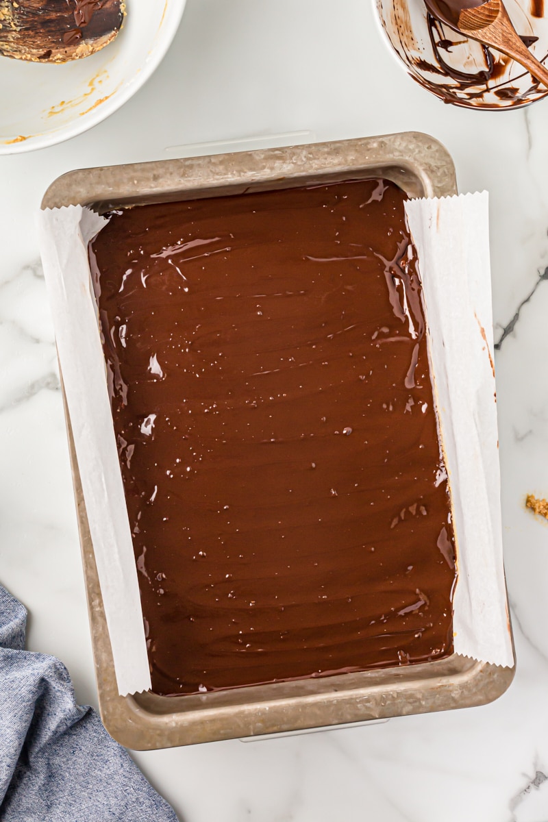 Overhead view of peanut butter chocolate bars after adding chocolate