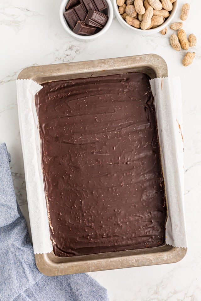 Overhead view of no-bake peanut butter bars in a parchment lined pan.