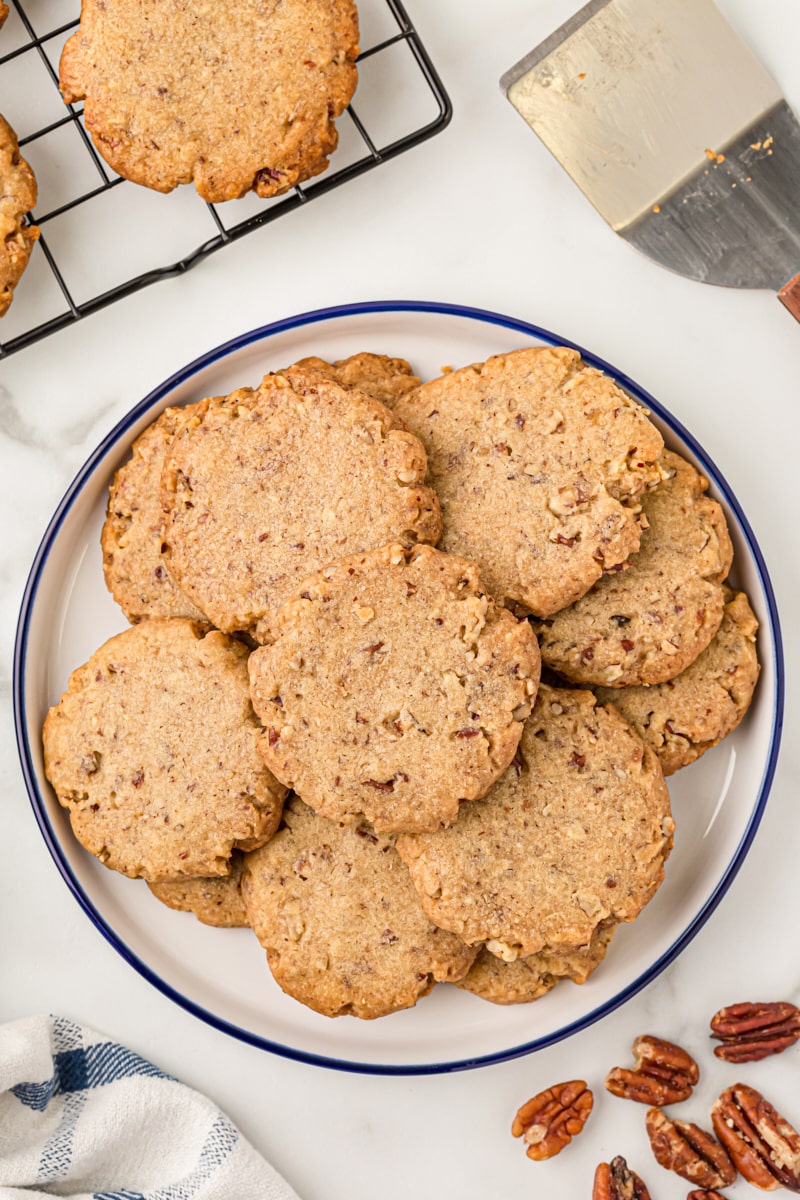 Overhead view of pecan sandies stacked on a plate.