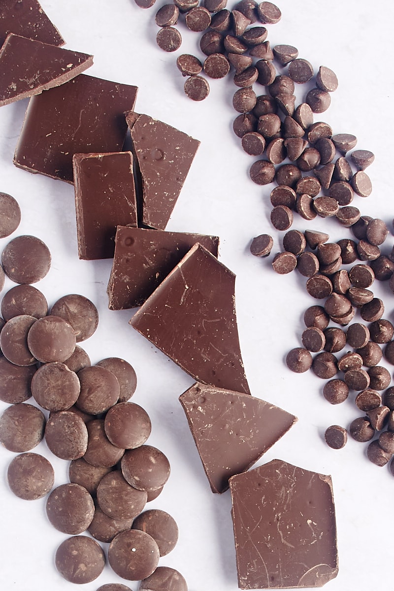overhead view of chocolate chips, pieces of baking chocolate, and chocolate chips