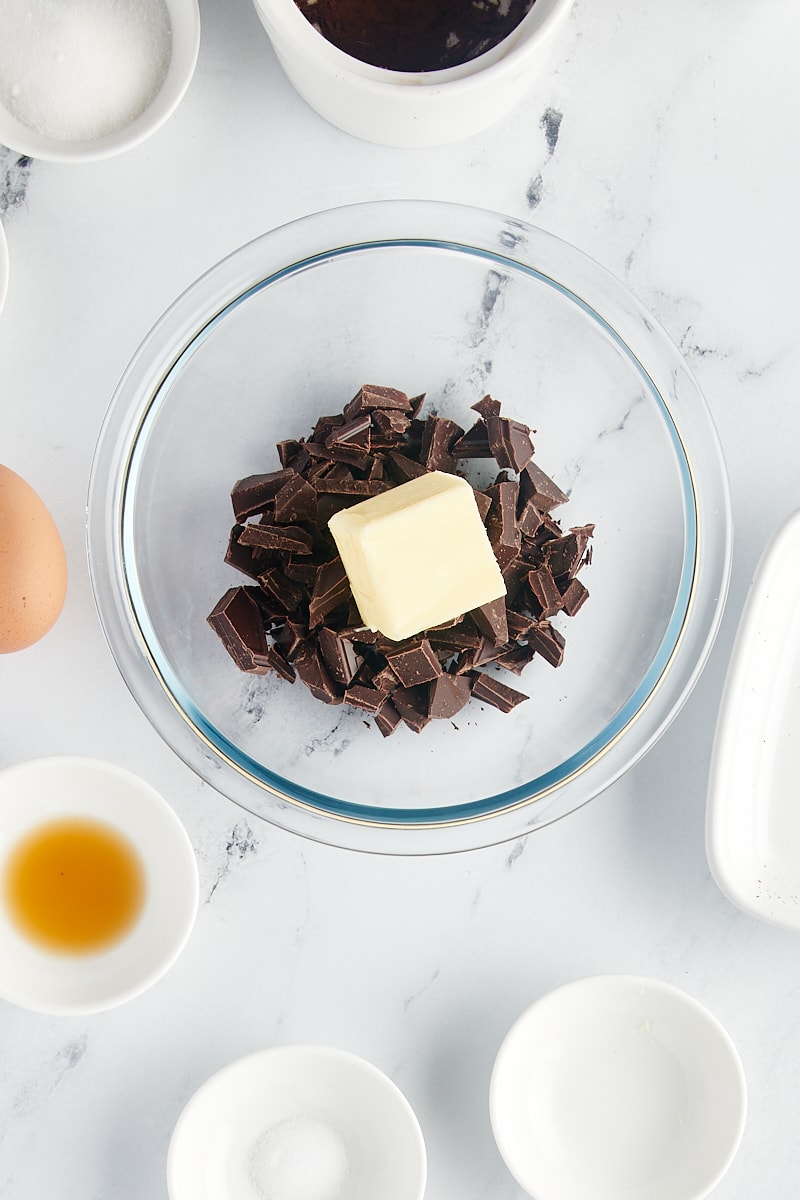 overhead view of dark chocolate and butter in a glass bowl
