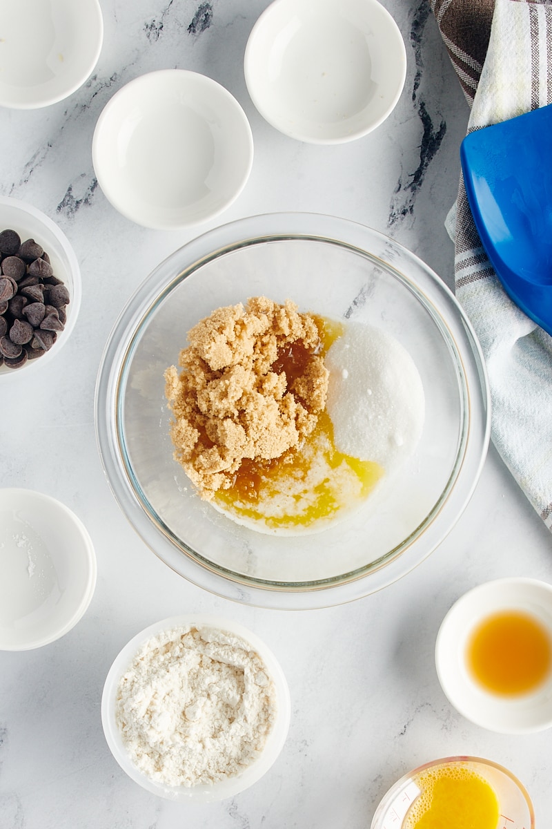 overhead view of brown sugar, sugar, and melted butter in a glass mixing bowl