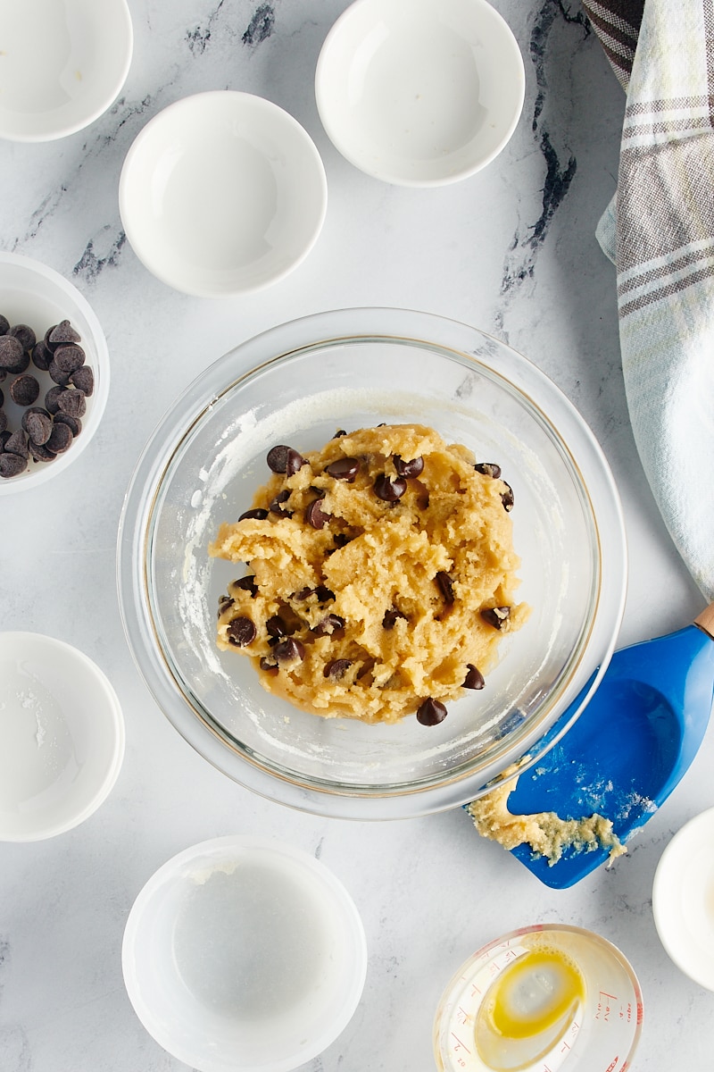 overhead view of mixed chocolate chip cookie dough in a glass mixing bowl