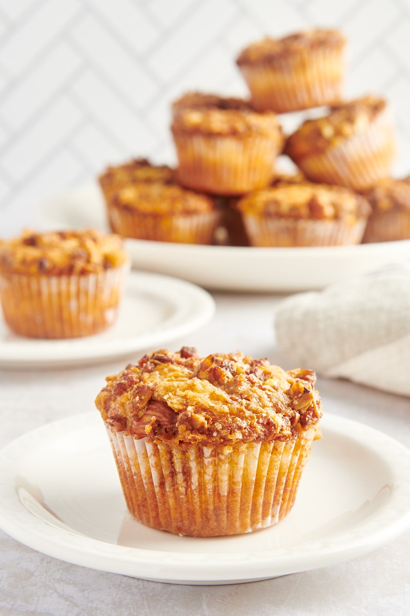 Single granola yogurt muffin on plate with additional muffins in background