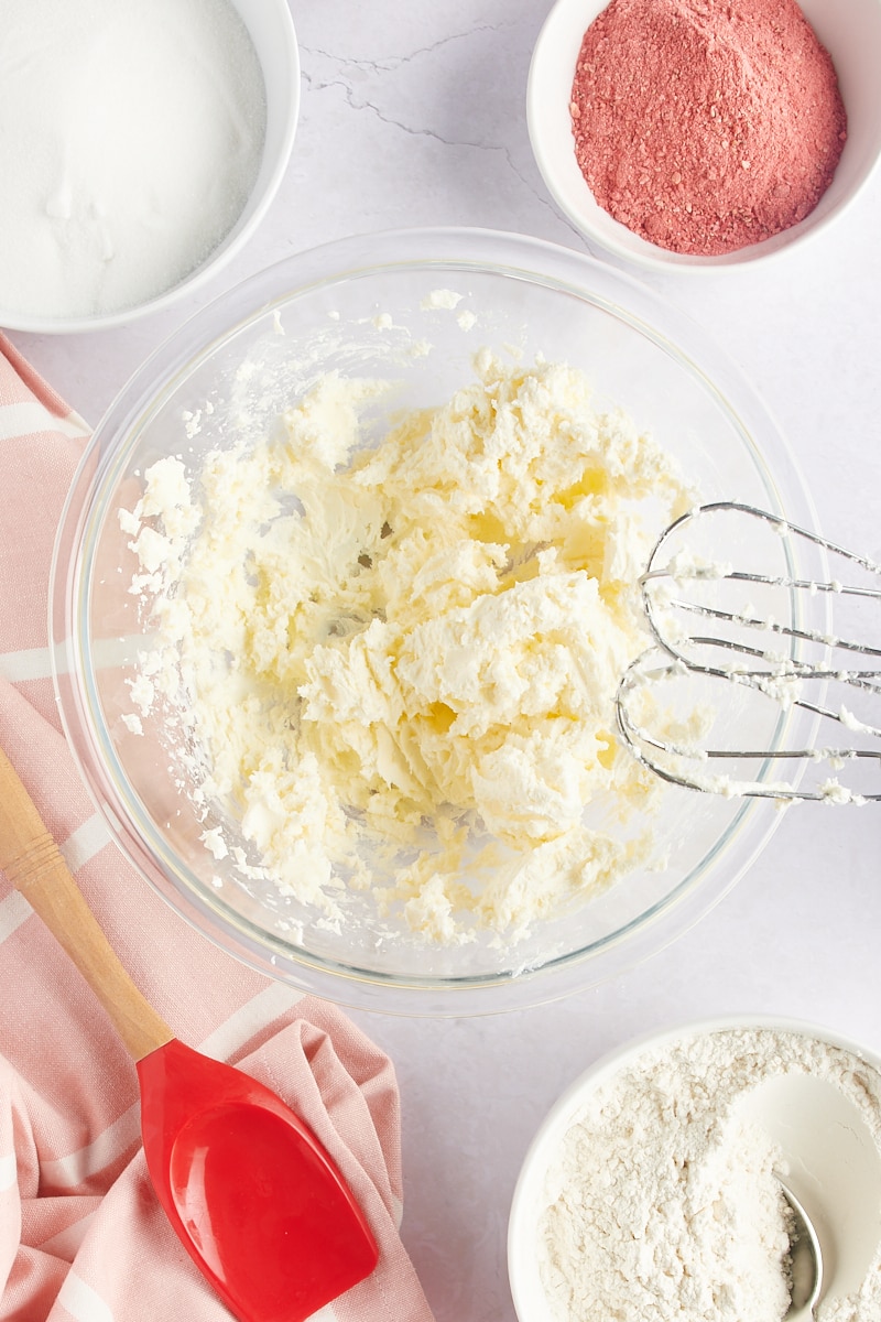 overhead view of creamed butter and cream cheese in a glass mixing bowl