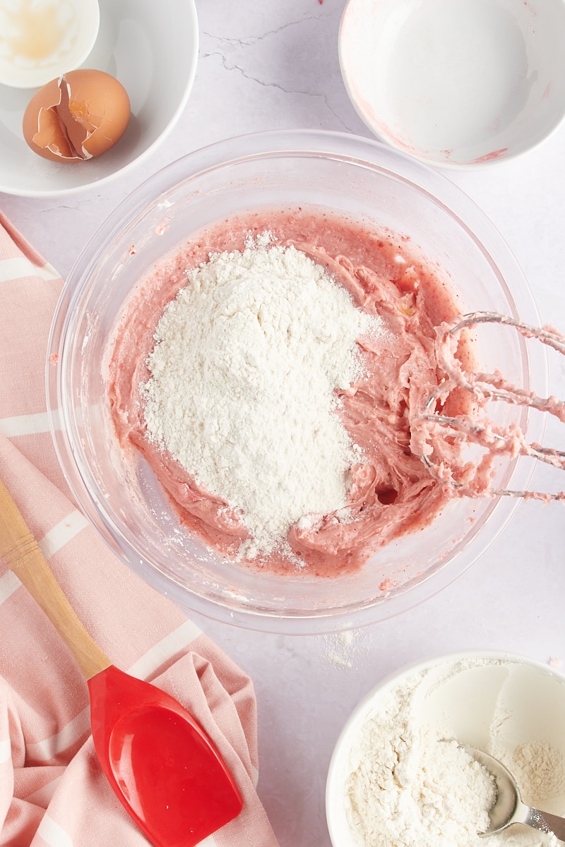 overhead view of dry ingredients added to strawberry cookie dough