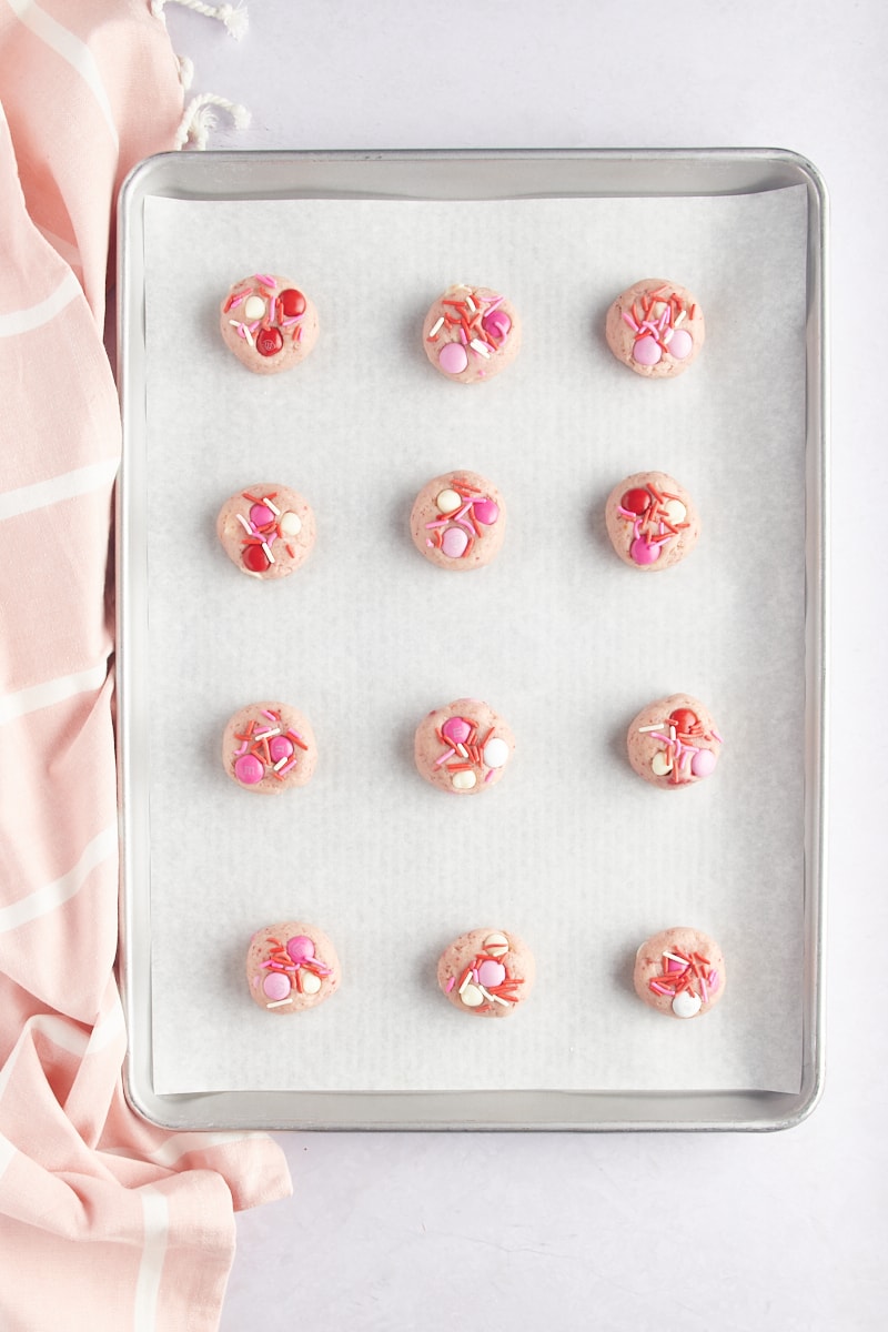 overhead view of Strawberry M&M Cookie dough on a parchment-lined baking sheet